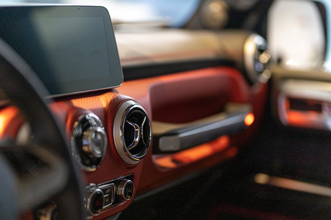 Close-up of a modern cars interior focusing on the digital dashboard and air vents.